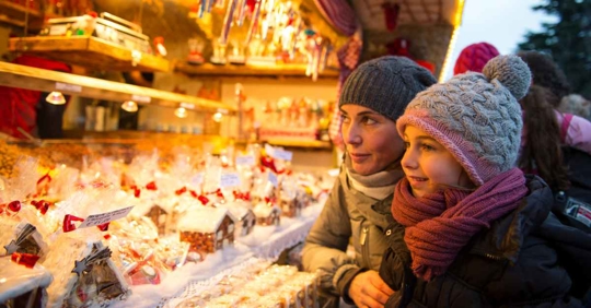A mother and child looking at a Christmas market