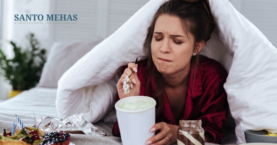 Woman in bed eating ice cream.